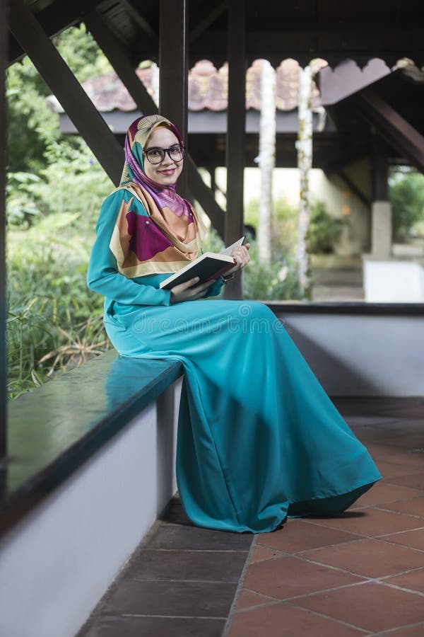 Fille musulmane tenant le livre au parc photographie stock Fille musulmane tenant le livre au parc photographie stock