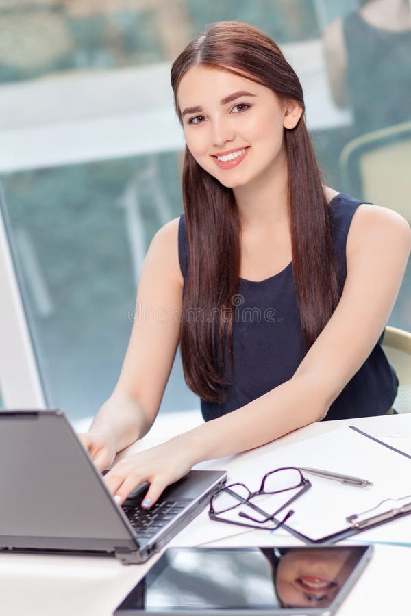 Fille optimiste s'asseyant avec l'ordinateur portable images stock