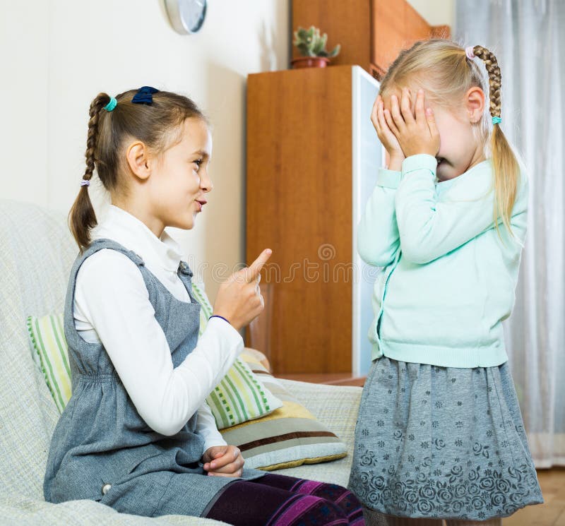 Fille parlant la petite soeur dans l'intérieur domestique photo stock Fille parlant la petite soeur dans l'intérieur domestique photo stock