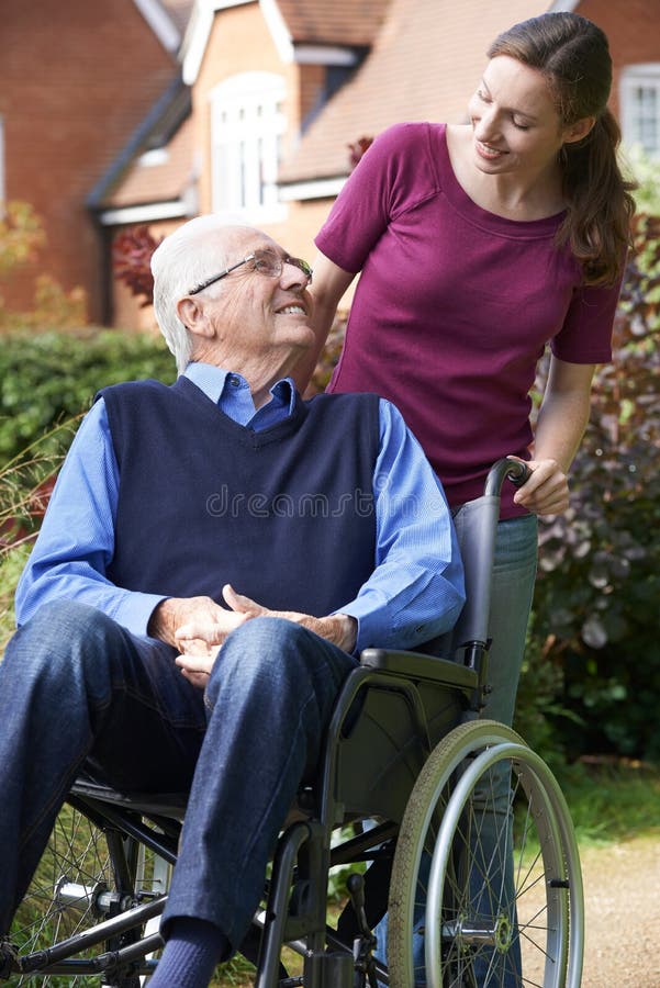 Fille poussant le père supérieur In Wheelchair photographie stock Fille poussant le père supérieur In Wheelchair photographie stock