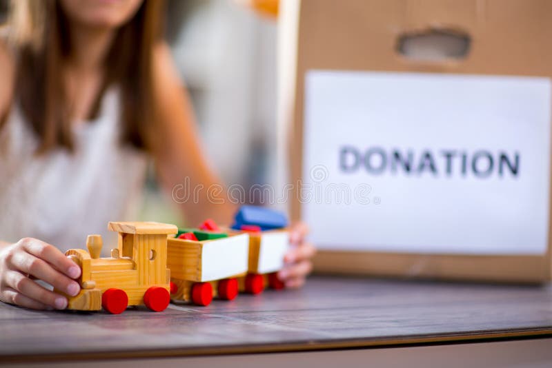 Fille prenant le jouet pour la donation photographie stock libre de droits Fille prenant le jouet pour la donation photographie stock libre de droits