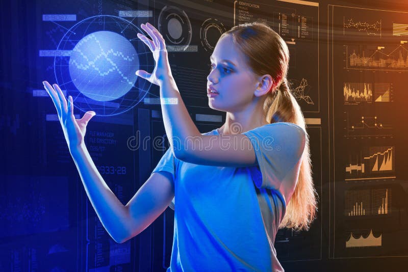 Fille progressive tenant un hologramme et le regardant photos stock Fille progressive tenant un hologramme et le regardant photos stock