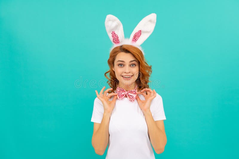Fille pâques heureuse dans les oreilles de lapin et noeud arc sur fond bleu images libres de droits