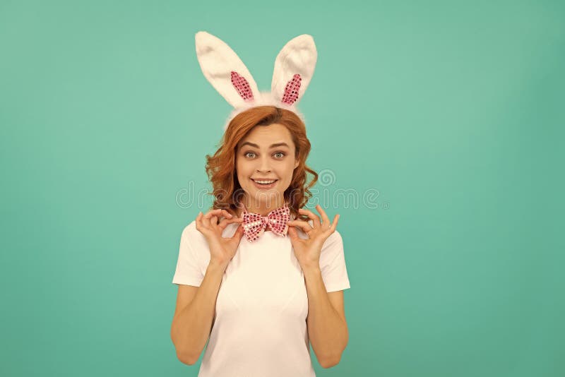 Fille pâques heureuse dans les oreilles de lapin et noeud arc sur fond bleu photographie stock libre de droits
