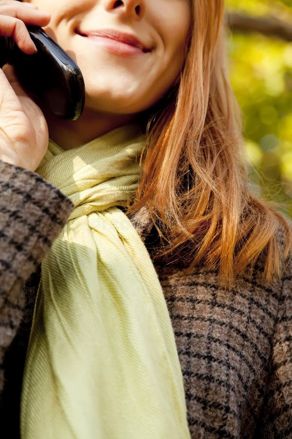 Fille Red-haired appelant par le téléphone photo stock Fille Red-haired appelant par le téléphone photo stock