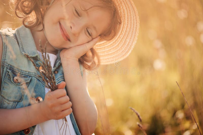 Fille rêvante heureuse d'enfant tenant le bouquet en été photos stock Fille rêvante heureuse d'enfant tenant le bouquet en été photos stock