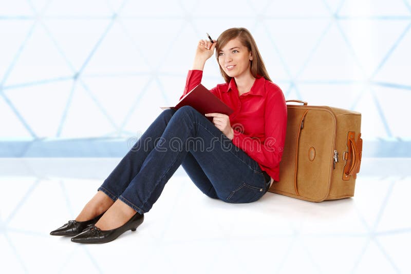 Fille s'asseyant près d'une valise