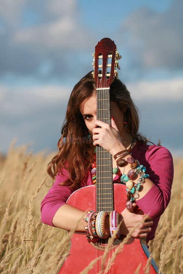 Fille se cachant derrière une guitare photo stock Fille se cachant derrière une guitare photo stock