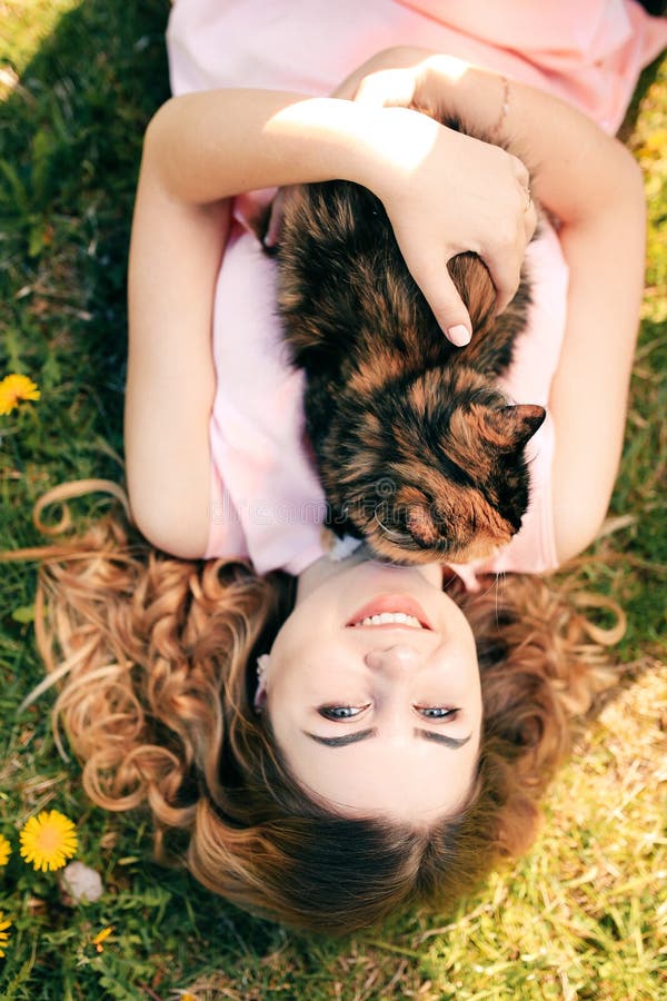 Fille se trouvant sur l'herbe avec le chat sur le concept chaud de ressort de coffre ou de temps d'été Fond de Bokeh Chaton de gi photos stock Fille se trouvant sur l'herbe avec le chat sur le concept chaud de ressort de coffre ou de temps d'été Fond de Bokeh Chaton de gi photos stock