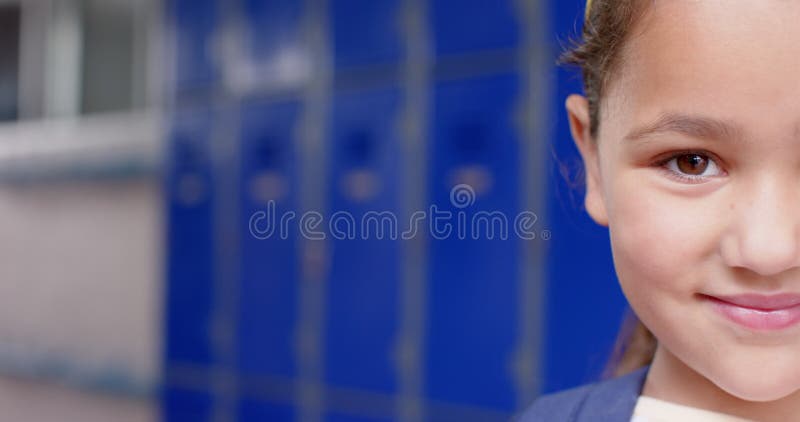 Fille souriante en uniforme d'école debout devant des casiers bleus copier l'espace banque de vidéos