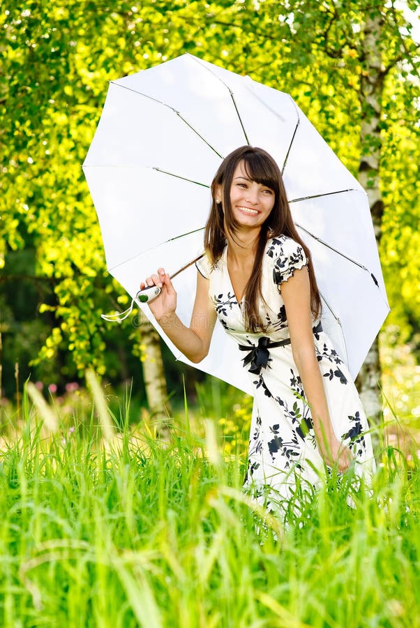 The young beautiful woman in a birchwood hides from sun under white umbrella. The young beautiful woman in a birchwood hides from sun under white umbrella.