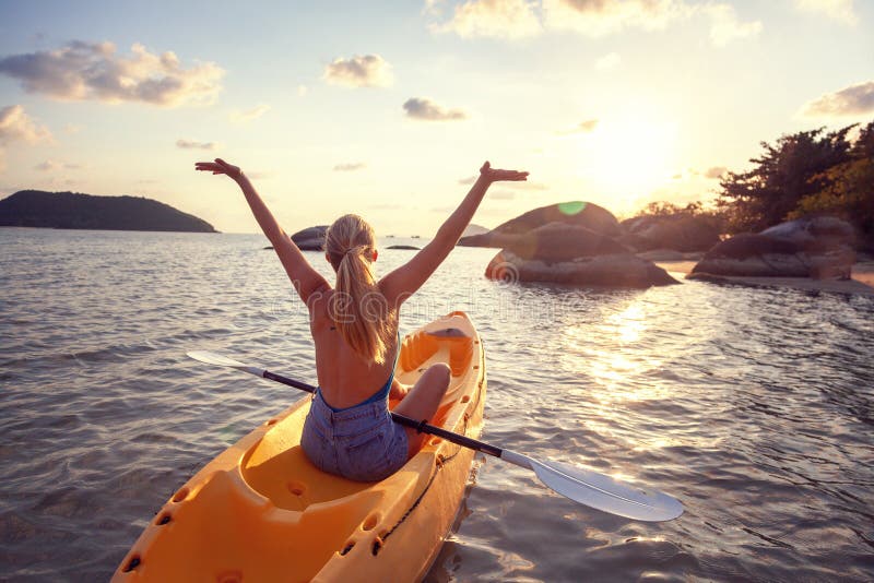 Fille sur la mer de kayak au coucher du soleil, conception saine de mode de vie Sport, récréation, aventure dehors photo libre de droits Fille sur la mer de kayak au coucher du soleil, conception saine de mode de vie Sport, récréation, aventure dehors photo libre de droits