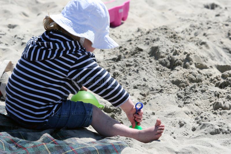 Girl on the beach playing with sand. Girl on the beach playing with sand