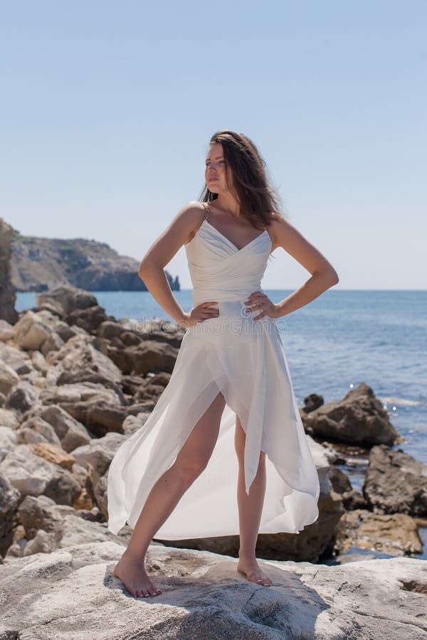 Fille sur le bord de la mer rocheux photos stock Fille sur le bord de la mer rocheux photos stock