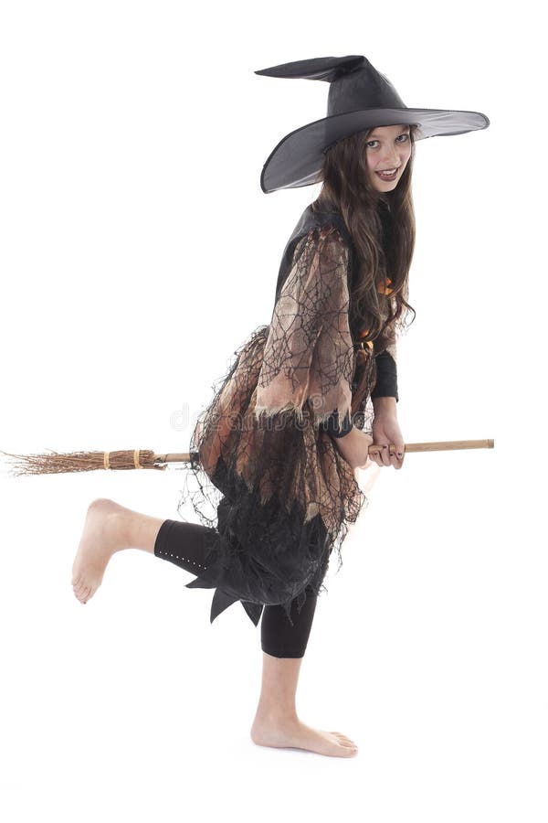 Young girl in costume Halloween witch in black dress and hat fly on broom. Young girl in costume Halloween witch in black dress and hat fly on broom