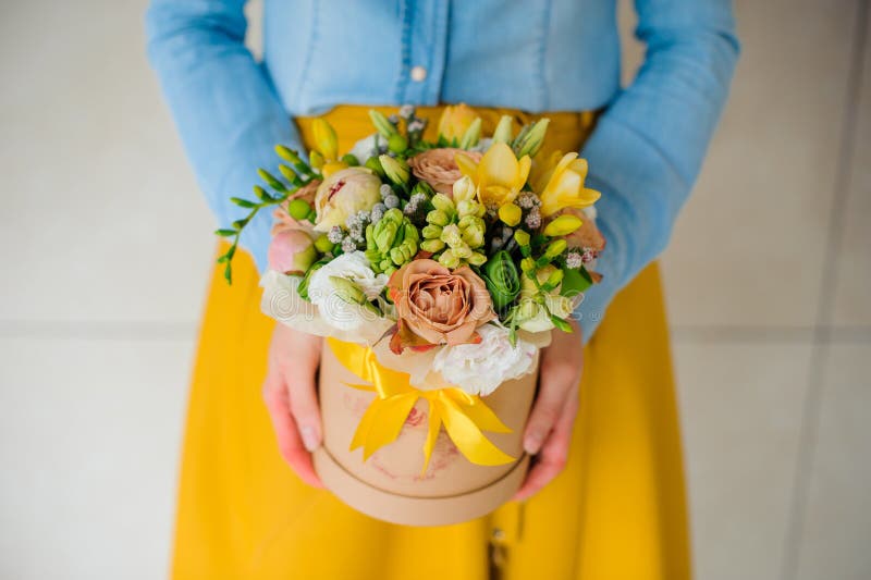 Fille tenant le beau bouquet de fleur de mélange dans la boîte ronde avec le couvercle images libres de droits Fille tenant le beau bouquet de fleur de mélange dans la boîte ronde avec le couvercle images libres de droits