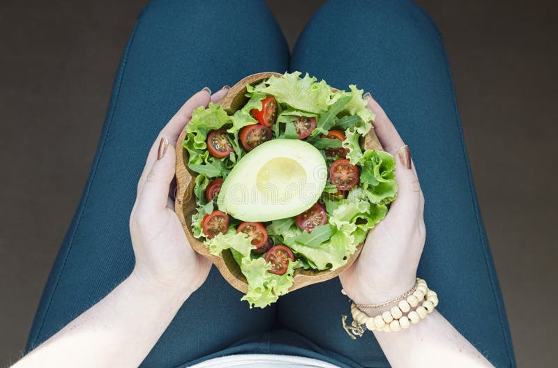 Fille tenant une salade verte d'avocat photo stock Fille tenant une salade verte d'avocat photo stock