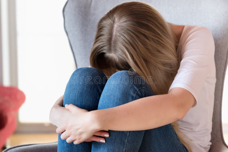 Fille triste s'asseyant sur la présidence photographie stock libre de droits Fille triste s'asseyant sur la présidence photographie stock libre de droits