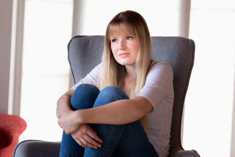 Fille triste s'asseyant sur la présidence image stock Fille triste s'asseyant sur la présidence image stock
