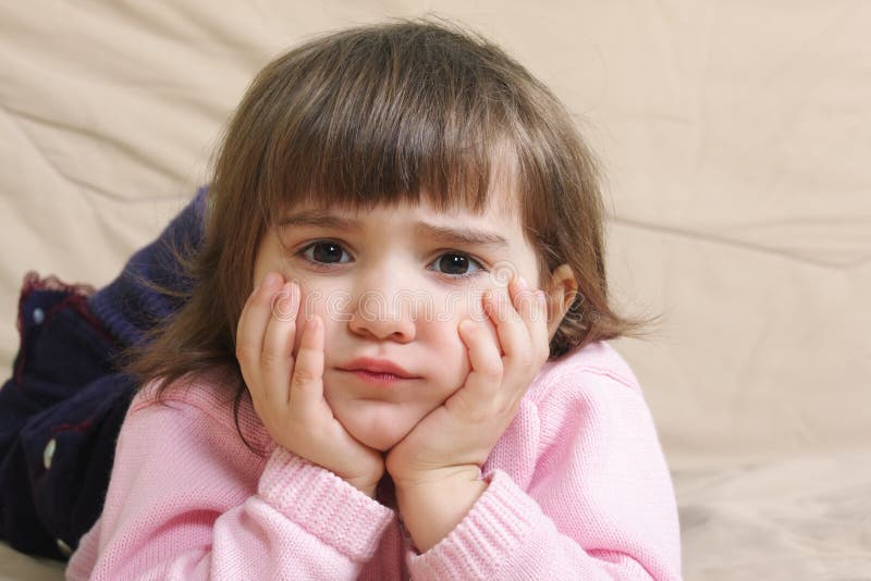 Fille triste sur le sofa photos libres de droits Fille triste sur le sofa photos libres de droits