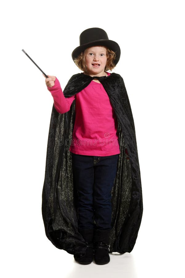 Fille étonnée habillée en tant que tache floue de mouvement de magicien sur la baguette magique images stock Fille étonnée habillée en tant que tache floue de mouvement de magicien sur la baguette magique images stock