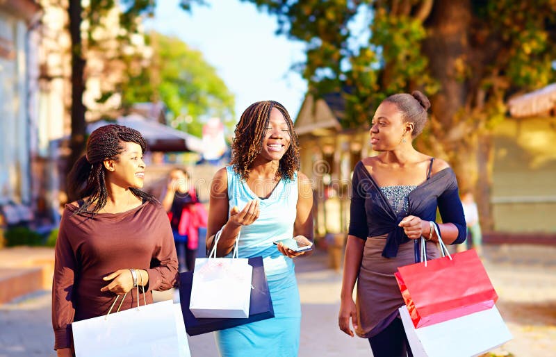 Filles africaines heureuses marchant la rue avec des paniers photo stock Filles africaines heureuses marchant la rue avec des paniers photo stock
