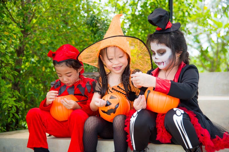 Filles dans le costume de Halloween se reposant sur l'escalier et le sourire images stock Filles dans le costume de Halloween se reposant sur l'escalier et le sourire images stock