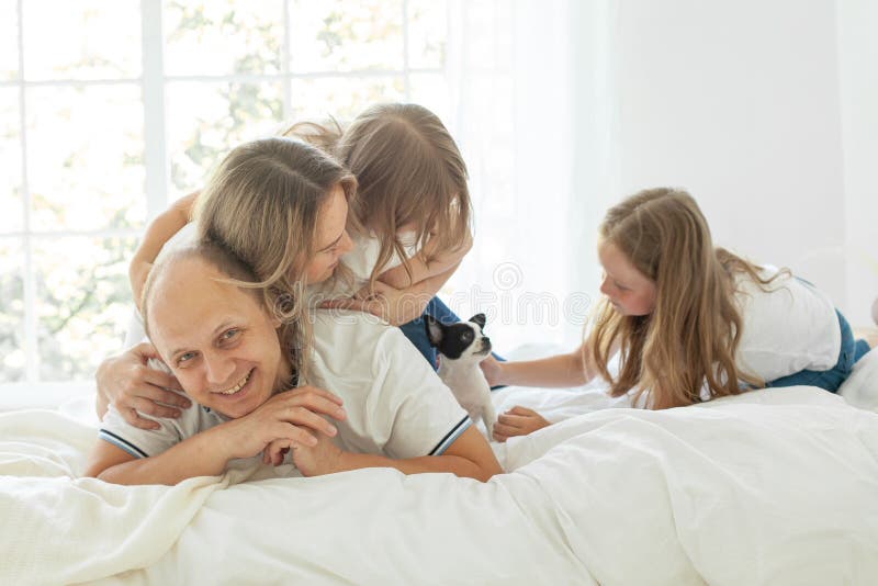 Filles de père mère et petit chien à la maison. Famille heureuse photo libre de droits