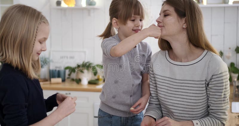Filles essuyer la farine des mères visage dans la cuisine banque de vidéos