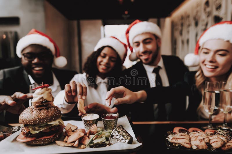 Filles et types Hamburger chapeau s Santa Les jeunes photos libres de droits Filles et types Hamburger chapeau s Santa Les jeunes photos libres de droits