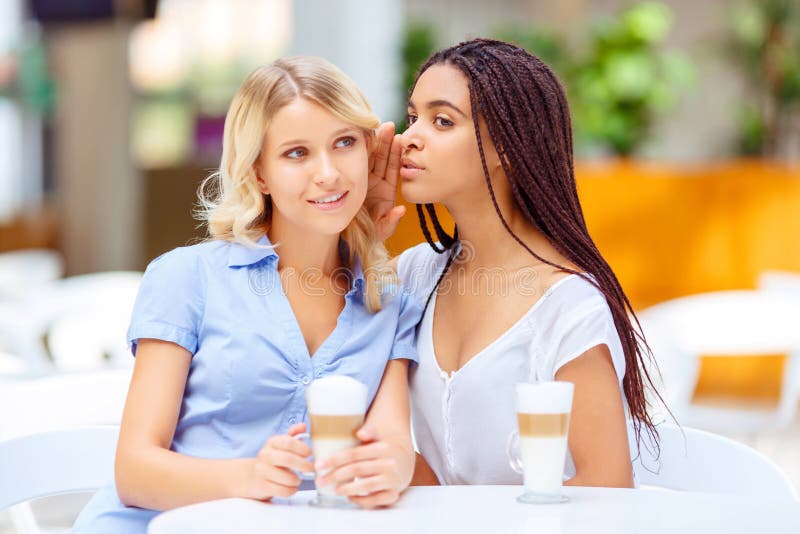 Filles heureuses s'asseyant dans le café image stock