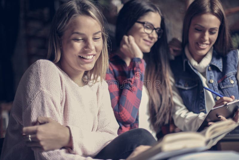 Filles souriantes d'étudiants apprenant ensemble photo stock Filles souriantes d'étudiants apprenant ensemble photo stock