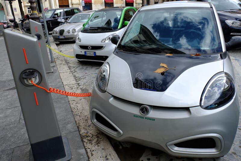 Filling station for electric cars. Event: Inauguration filling station electric cars. ROME, ITALY - NOVEMBER 19, 2014: Electric cars charging on a street in the royalty free stock image Filling station for electric cars. Event: Inauguration filling station electric cars. ROME, ITALY - NOVEMBER 19, 2014: Electric cars charging on a street in the royalty free stock image