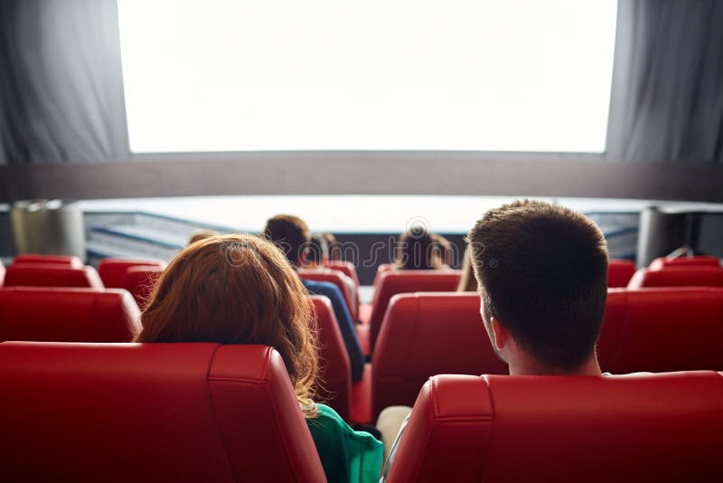 Film di sorveglianza delle coppie felici nel teatro o in cinema immagine stock libera da diritti Film di sorveglianza delle coppie felici nel teatro o in cinema immagine stock libera da diritti
