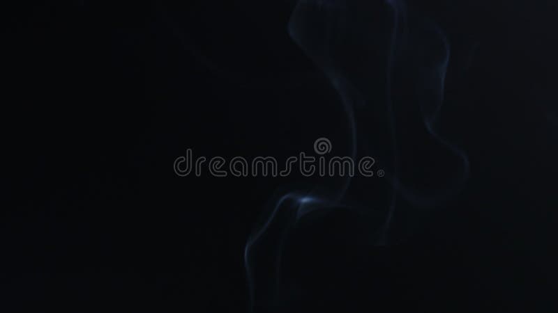 Filmagem reversa da fumaça azul sobre fundo preto