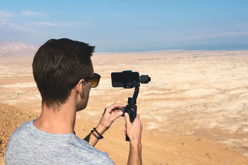 Young man using gimbal in the desert of israel royalty free stock images Young man using gimbal in the desert of israel royalty free stock images