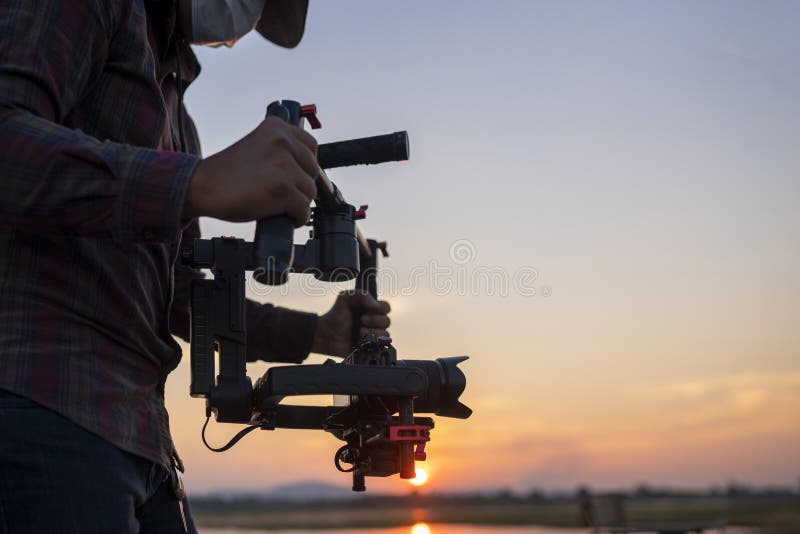 Filmmaker or content creator using stabilizer gimbal camera take video footage on the location outdoor royalty free stock photo