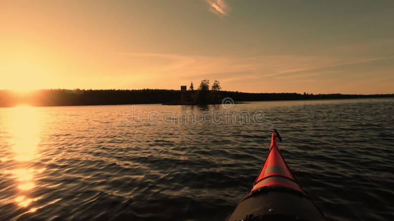 Films de caméra d'action kayak dans l'eau calme. Silhouettes de petite île avec la forêt de peu d'arbres sur le littoral et bien d