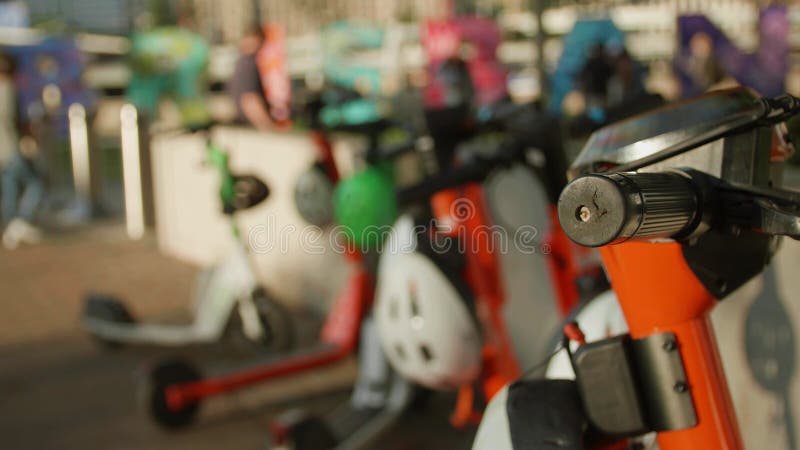 Films de fermeture de scooters électriques garés dans une rangée par une journée ensoleillée dans le parc banque de vidéos