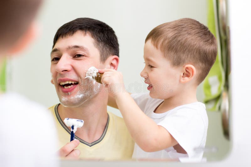 Fils de père et d'enfant rasant ensemble à la maison photographie stock libre de droits Fils de père et d'enfant rasant ensemble à la maison photographie stock libre de droits