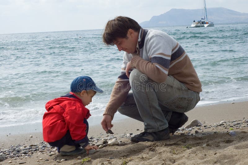 Fils heureux de pièce de père de plage images libres de droits