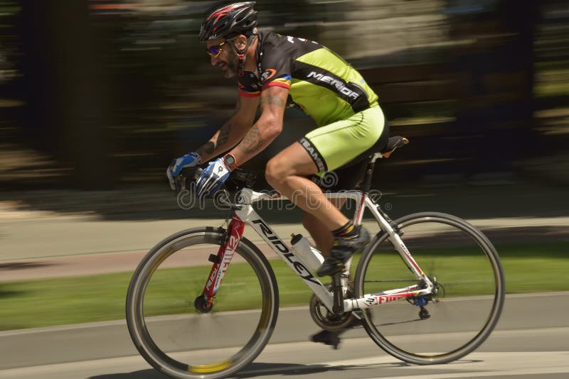 Filtração de uma bicicleta da equitação do ciclista em um dia ensolarado, competindo para o evento grande de Prix da estrada, uma