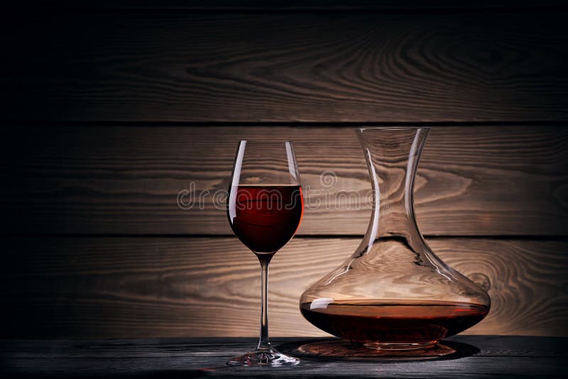 Filtro e vidro com vinho tinto em uma tabela de madeira