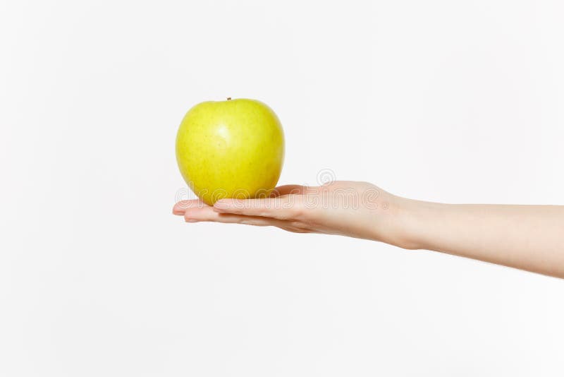 Fim acima das posses fêmeas à disposição na maçã fresca do verde da palma isolada no fundo branco Nutrição apropriada, alimento d foto de stock Fim acima das posses fêmeas à disposição na maçã fresca do verde da palma isolada no fundo branco Nutrição apropriada, alimento d foto de stock