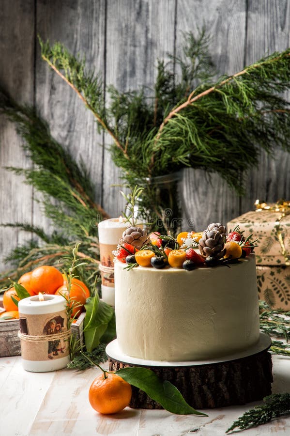 Fim acima O bolo de ano novo, mirtilos decorados, morangos, kumquat Estão próximo as tangerinas alaranjadas, queimando velas fest fotos de stock Fim acima O bolo de ano novo, mirtilos decorados, morangos, kumquat Estão próximo as tangerinas alaranjadas, queimando velas fest fotos de stock