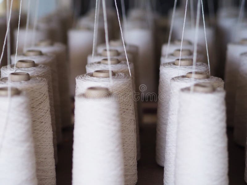 Textile threads industry cotton sewing spools close up. Textile threads industry cotton sewing spools close up