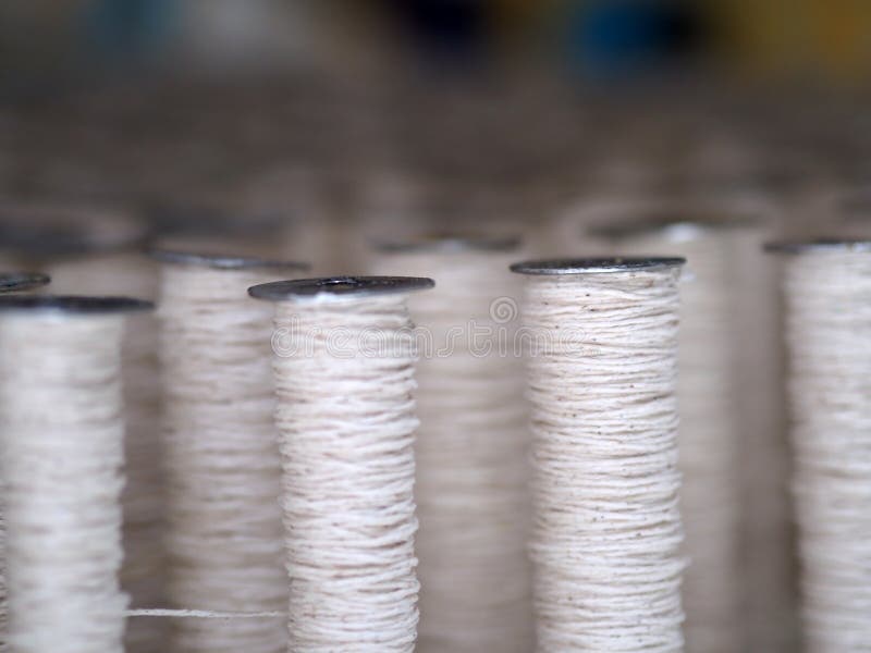 Textile threads industry cotton sewing spools close up. Textile threads industry cotton sewing spools close up