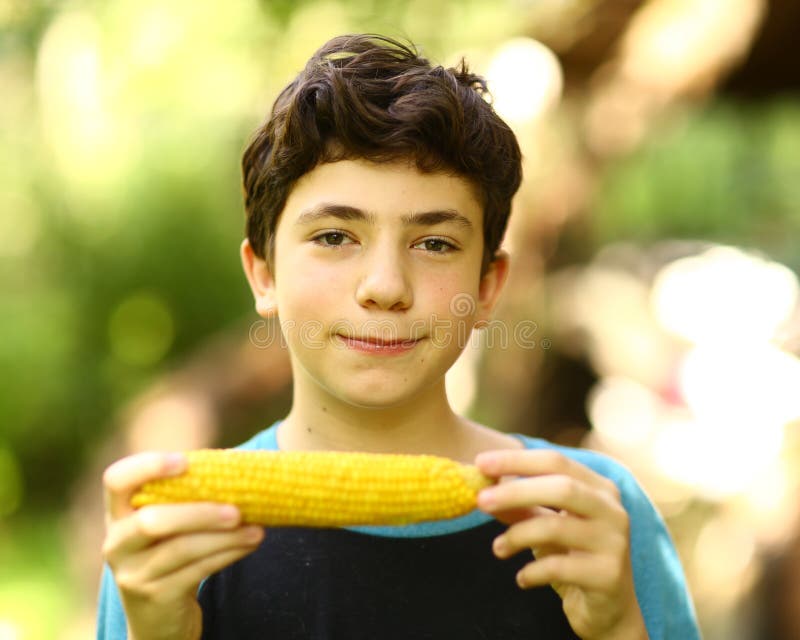 Fim fervido comer da espiga de milho do menino do adolescente acima da foto fotografia de stock Fim fervido comer da espiga de milho do menino do adolescente acima da foto fotografia de stock
