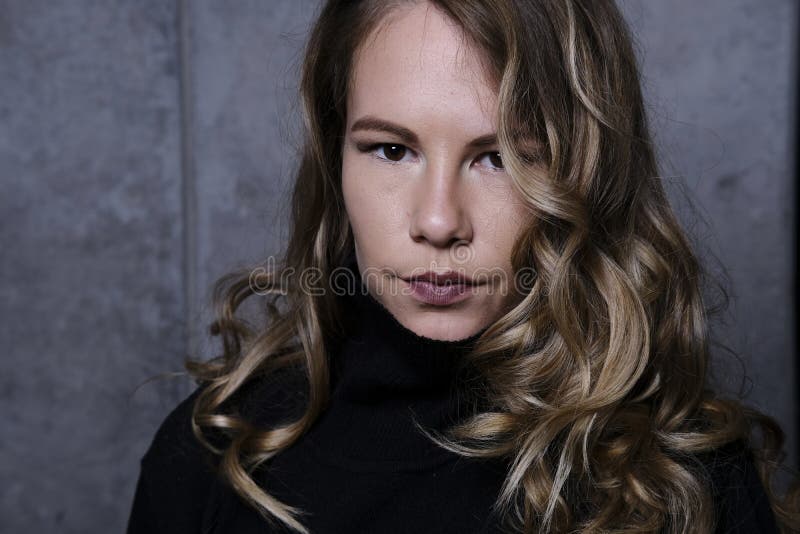 Fin de stupéfaction d'une blonde dans le chandail noir photos stock