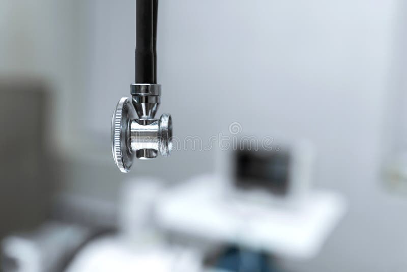 Fin de stéthoscope sur le fond de la salle d'opération Fond brouillé de la clinique et du matériel médical images libres de droits